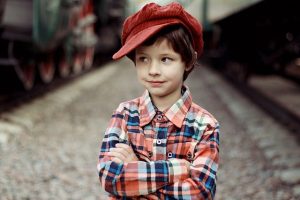 Foto de um menino com camisa xadrez e boné vermelho para demonstrar visão normal