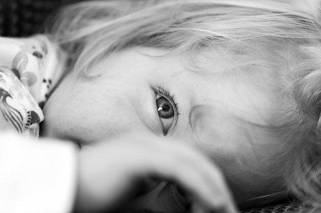 Criança pequena em preto e branco com reflexo no olho