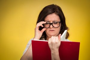 Mulher lendo sobre as diferenças entre miopia hipermetropia e astigmatismo