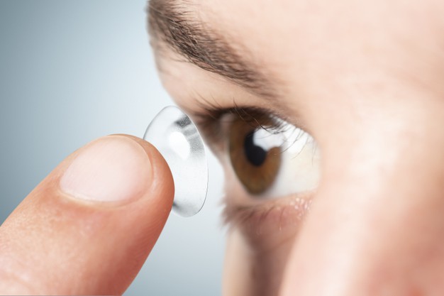 imagem aproximada de uma mulher colocando suas lentes nos olhos