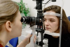 Oftalmologista examinando o olho de paciente com fungo no olho em laboratório.