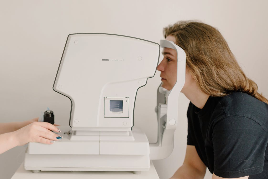Médico oftalmologista examinando uma mulher com fungo no olho com um rastreador de visão.