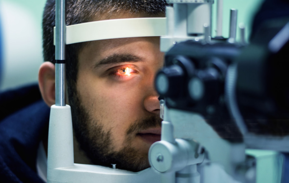 Homem à frente de uma máquina realizando check-up oftalmológico