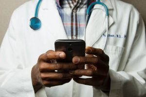 Médico usa o celular para conferir o preço de consulta oftalmológica