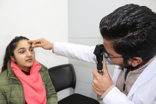 Médico realiza exame de mapeamento de retina em uma mulher