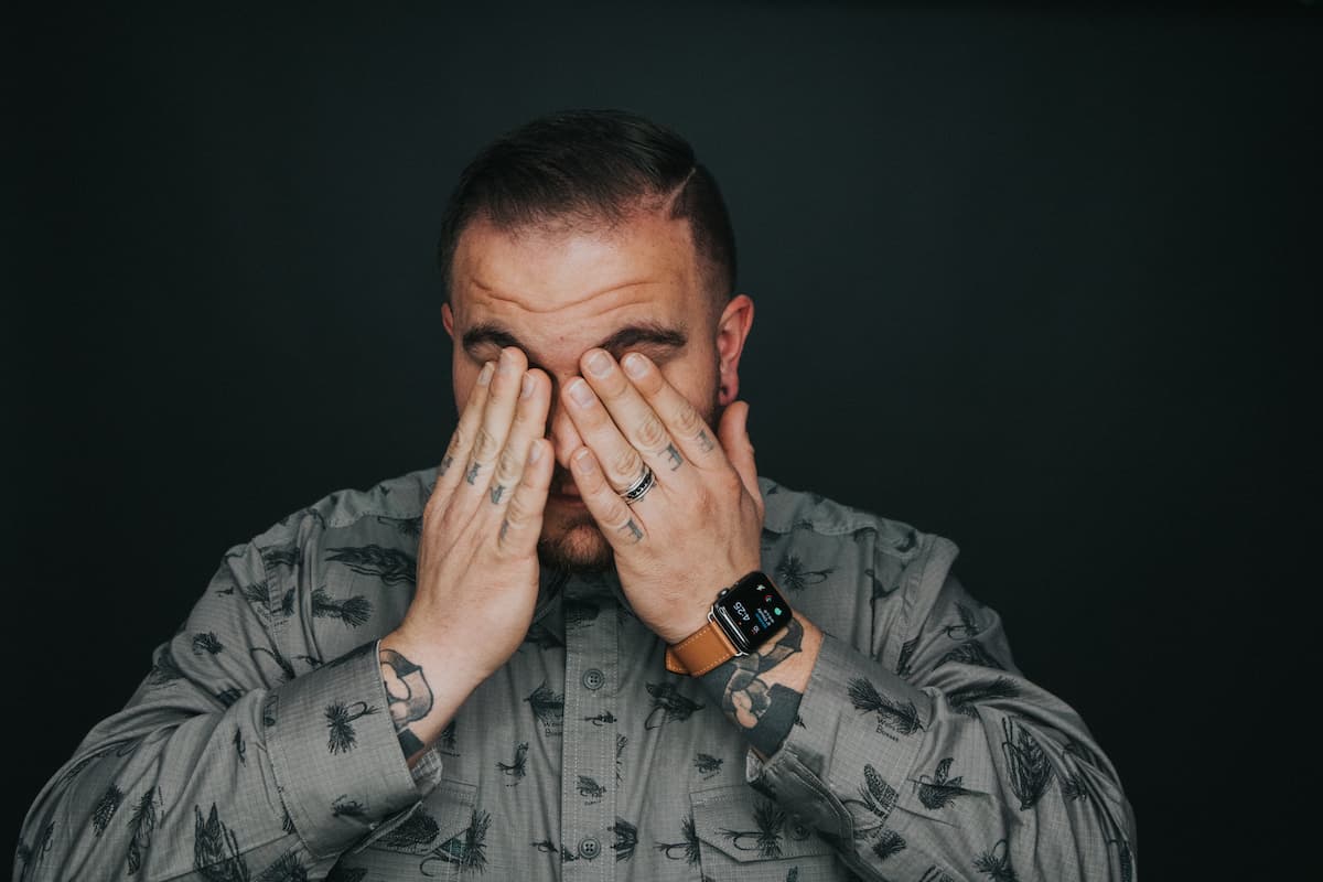 Um homem coçando seus olhos