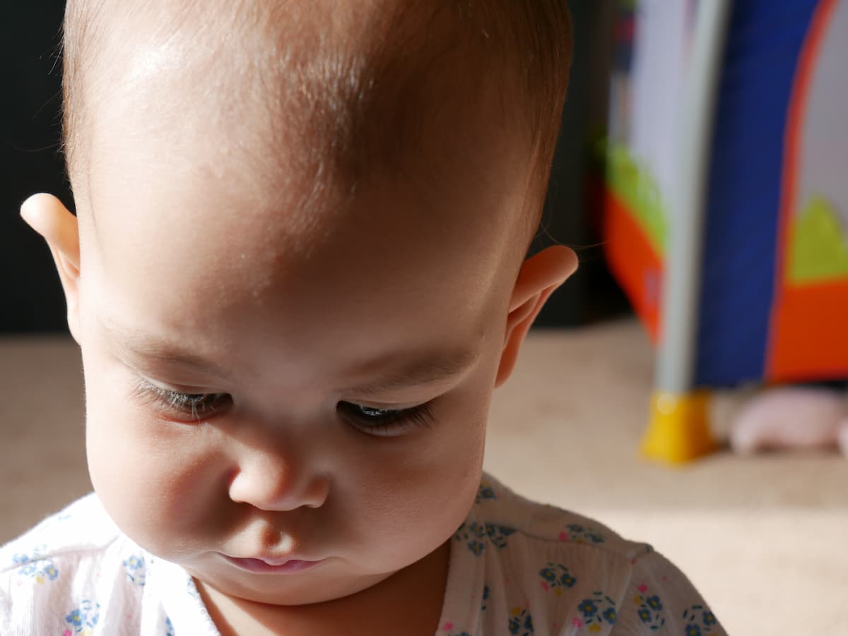 Um bebê olhando para baixo