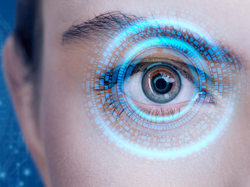 A imagem é um close-up de um olho humano com um efeito de tecnologia e interface digital sobreposto.