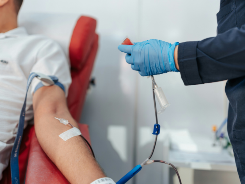 A imagem captura um momento em um centro de doação de sangue ou procedimento médico similar.