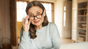 Esta imagem apresenta uma mulher de meia-idade com uma expressão serena e intelectual.