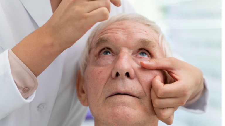 Fo mostra um idoso colocando colírio nos olhos