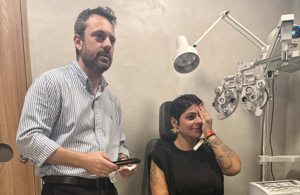 Paciente cobre o olho para exame na clínica de oftalmologia.