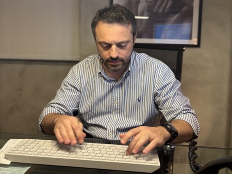 doutor ricardo filippo oftalmologia digitando na sala de sua clínica em campo grande