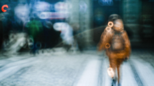A imagem apresenta uma fotografia artística bastante desfocada (out of focus) e abstrata, gravada em um ambiente urbano noturno ou sob clima frio/chuvoso.